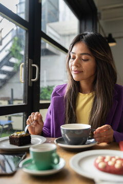 Woman enjoying quiet coffee time with dessert in cafe