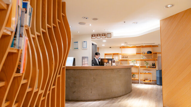 Modern hotel lobby with Taiwanese receptionist at front desk