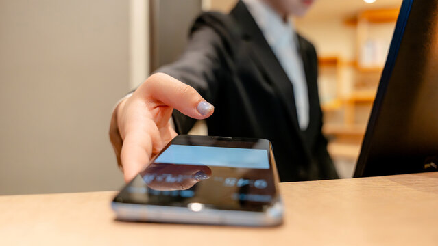 Hotel receptionist offering mobile key at front desk