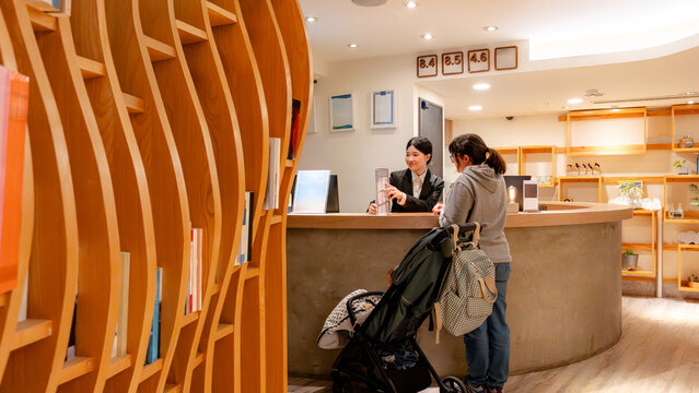 Taiwanese hotel receptionist assisting guest at front desk