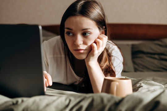 Relaxing day off in bed with a laptop and coffee