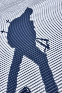 Shadow of a skier on grooved snowy surface