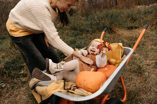 Girl and sister enjoying pumpkin harvest in autumn