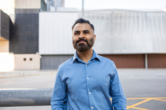 Arab businessman standing outdoors near modern office building