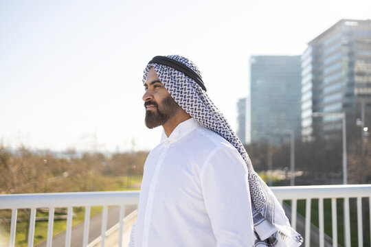 Arab sheikh businessman in traditional attire by skyline