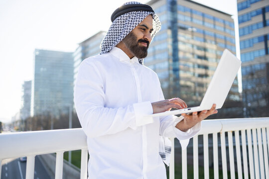 Arab sheikh businessman using laptop outside modern office