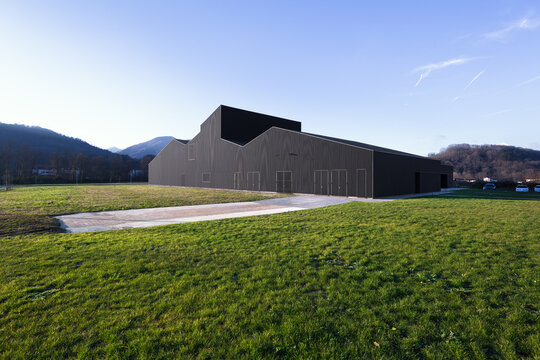 Modern candy factory warehouse in rural landscape at dusk