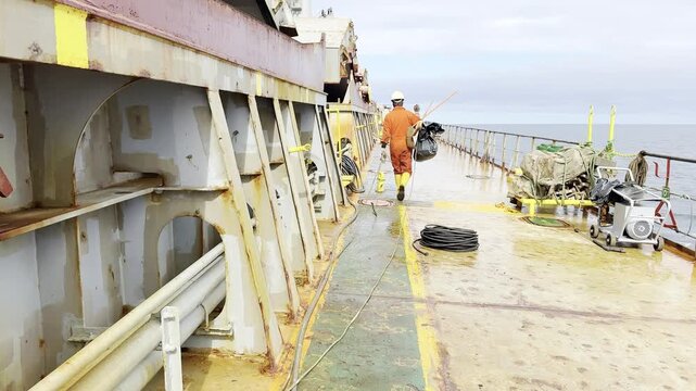 seafarers working on deck of cargo ship. ordinary duty of crew. cleaning, washing and maintenance. use protection, working clothes and equipment for maintenance