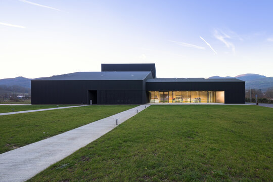Modern candy factory building with glass facade at dusk