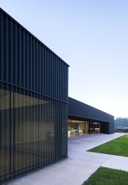 Modern candy factory building with glass facade at dusk