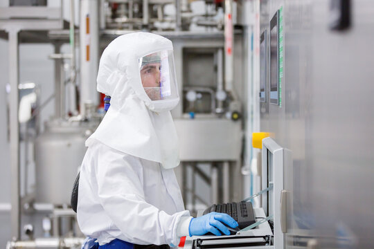 Technician in cleanroom operating candy factory control panel