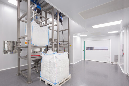 Clean candy factory room with bulk sugar bags and mixer