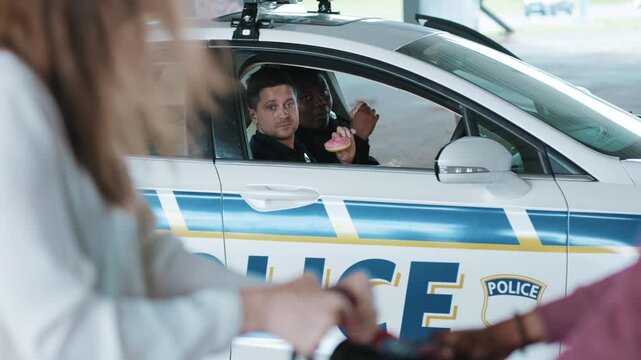 Slow motion two policemen eating donut smile talk see how a man steals a woman's bag near patrol car help happy african american break rest gangster uniform funny teamwork close up