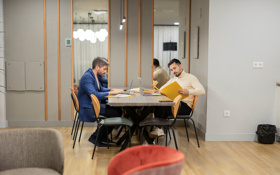 Coworking meeting with two professionals working at table