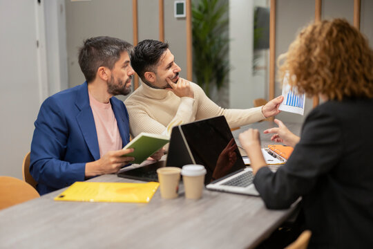 Coworking team reviewing financial chart during office meeting