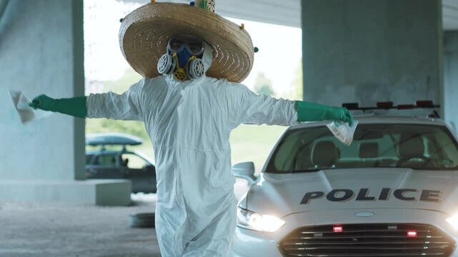 Shot of man in a funny costume big hat dancing with drugs near the police car uniform protection auto duty emergency portrait challenge crime security, cop close up slow motion