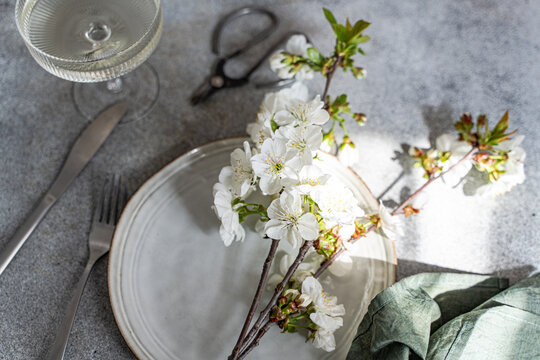 Spring table setting with cherry blossom branch indoors