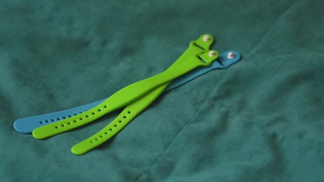 three access bracelet with a chip. Contactless silicone key card. Waterproof key bracelet. Functional RFID bracelet gadget on the bed in the hotel room. 