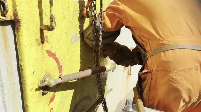 welding operations. ship fitter repair water tight metal door at mast house. spark, spangle, welding ark, weld joint 