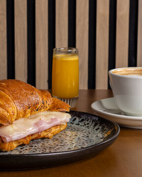 Morning breakfast with ham croissant, coffee and orange juice