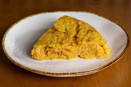 Slice of Spanish tortilla omelette on rustic plate