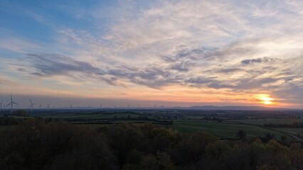 Obraz premium Countryside Sunset Over Open Fields With Dramatic Cloudy Sky
