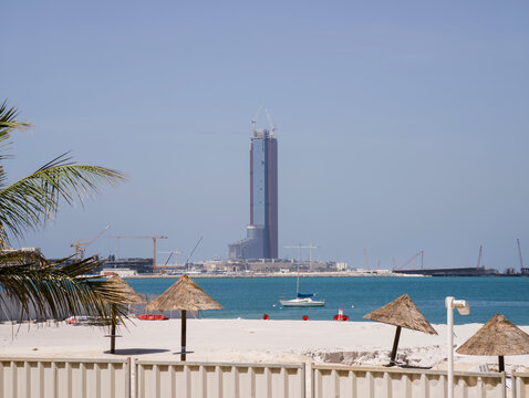 Ras al Khaimah, United Arab Emirates - April 18, 2026: A view of the Wynn casino under construction at Al Marjan Island, with a sandy beach and clear blue waters in the foreground.