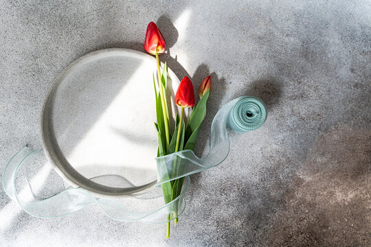 Minimal still life with red tulips on a gray table