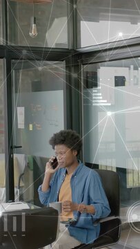 Vertical video: Mgr taking phone call while checking laptop solving business issue with HUD flowing