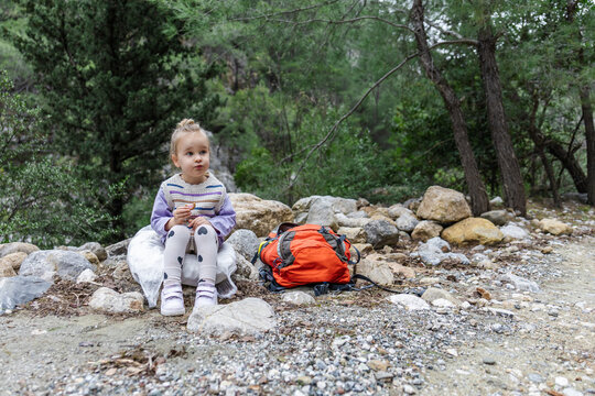 Family mountain adventure with child resting on trail