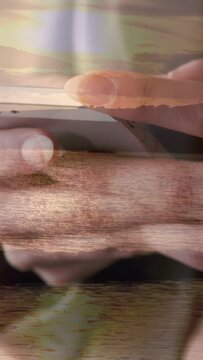 Vertical video: Vertical bands fading, hands holding white phone operating apps, coastline visible