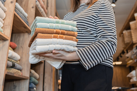 Woman holding neatly folded textiles in store