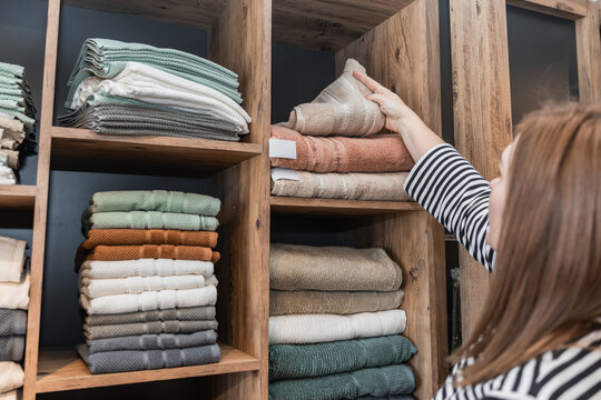 Woman selecting folded textiles in store