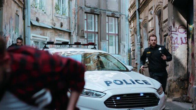 Police are in pursuit in a narrow urban alley, creating a scene of chaos and action