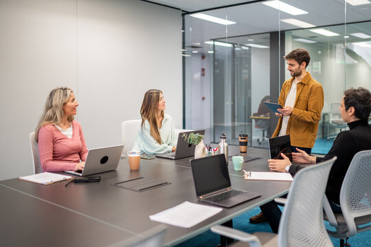 Coworking team meeting in modern office with laptop