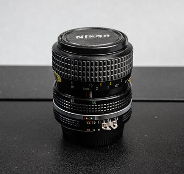 Gothenburg, Sweden - March 13 2026: Classic Nikon Nikkor zoom camera lens standing upright on textured surface.