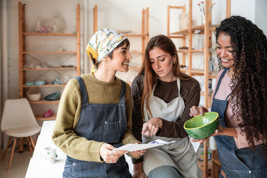 Potter students reviewing notes in a pottery workshop studio
