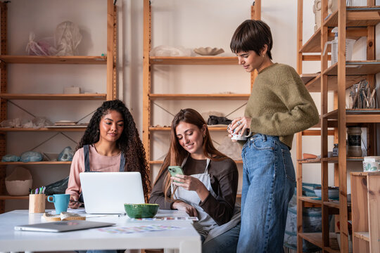 Potter team planning pottery workshop marketing on laptop