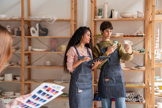 Pottery workshop team checking ceramic piece and color