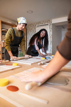 Pottery workshop class with artisans shaping clay at table