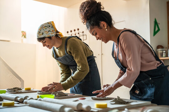 Pottery workshop friends shaping clay by hand at studio
