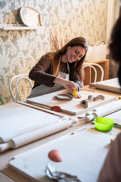 Woman shaping clay pottery in a cozy workshop studio