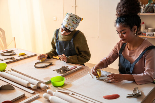 Pottery workshop with two women shaping clay at a table