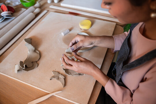 Person shaping clay by hand in a pottery workshop