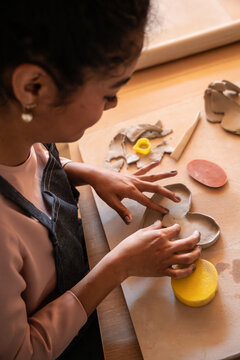 Pottery workshop artisan shaping clay bowl at worktable