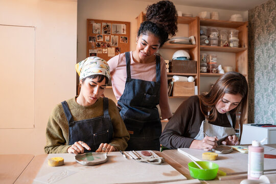 Pottery workshop with instructor guiding students at table
