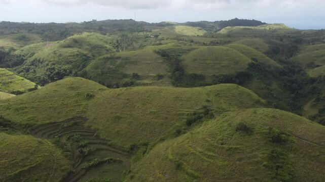 Cinematic aerial drone moving right across the scenic hills of Teletubbies Hill, Nusa Penida, Indonesia.