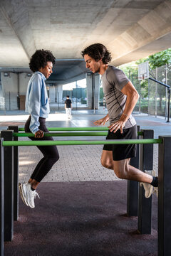 Outdoor partner dips workout at urban park fitness bars