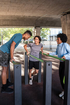 Outdoor calisthenics friends training on parallel bar