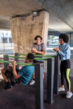 Group coaching pull up workout at outdoor calisthenics bar